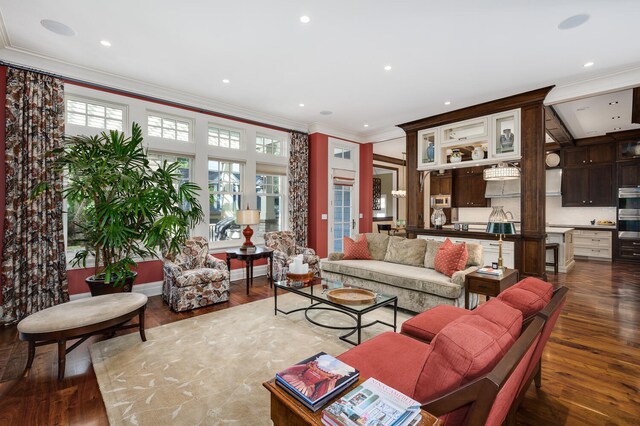 living room featuring built in desk, ornamental molding, and hardwood / wood-style floors