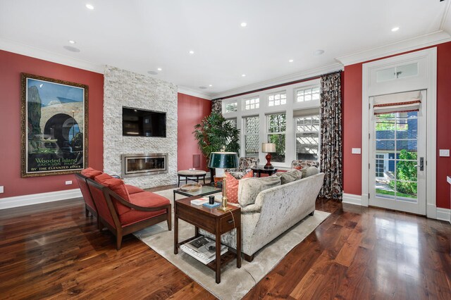 living room featuring crown molding, dark hardwood / wood-style flooring, and a fireplace