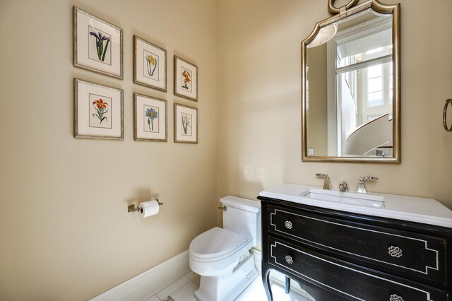 bathroom with toilet, vanity, and tile patterned floors