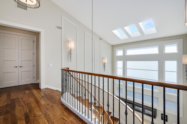 corridor featuring dark wood-type flooring and vaulted ceiling