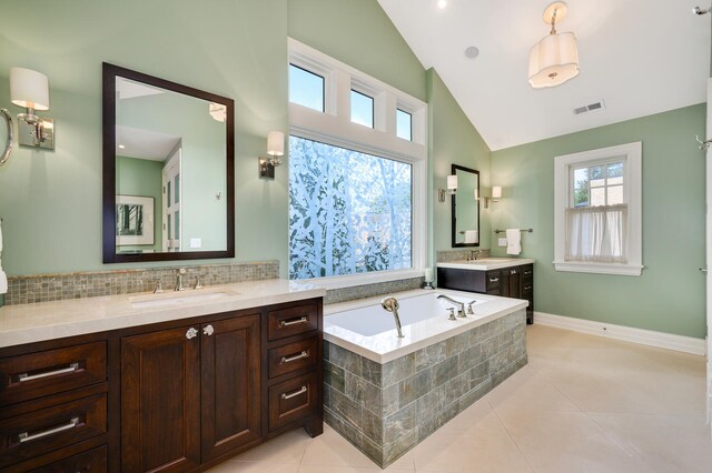 bathroom featuring tiled bath, backsplash, tile patterned floors, vanity, and high vaulted ceiling