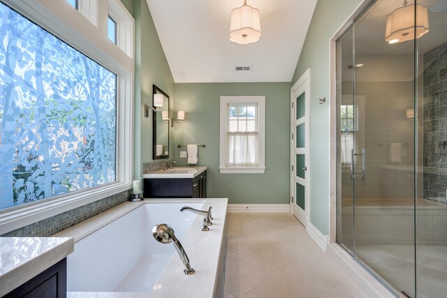 bathroom featuring vanity, independent shower and bath, lofted ceiling, and tile patterned floors