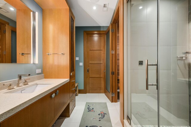 bathroom featuring vanity, a shower with shower door, and tile patterned flooring