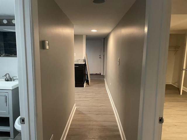 hallway featuring light hardwood / wood-style floors and sink