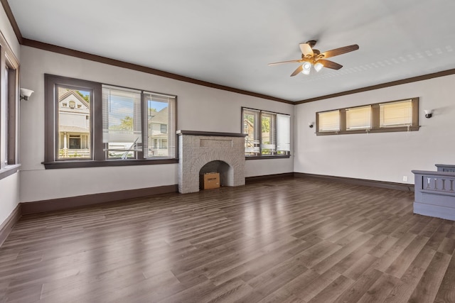 unfurnished living room featuring ceiling fan, crown molding, a fireplace, and dark wood-type flooring