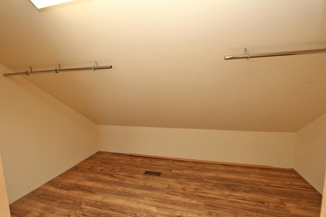 additional living space featuring vaulted ceiling and hardwood / wood-style floors