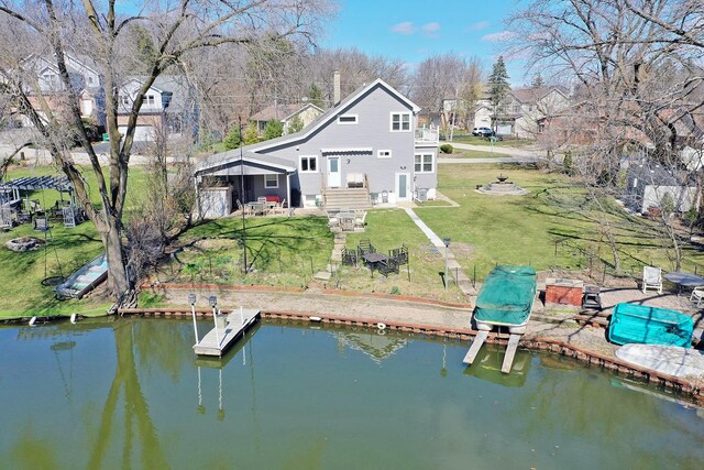 rear view of property with a water view and a yard