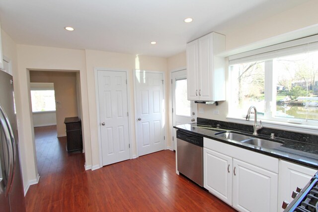 kitchen featuring sink, stainless steel appliances, white cabinetry, and dark wood-type flooring