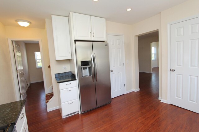 kitchen with stainless steel fridge, a wealth of natural light, white cabinetry, and dark wood-type flooring