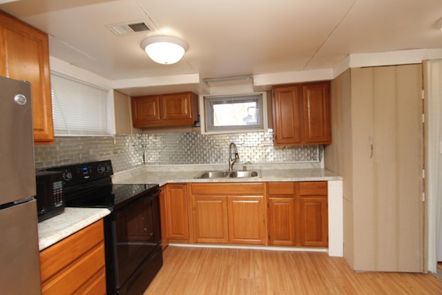 kitchen featuring light hardwood / wood-style floors, sink, electric range, and stainless steel refrigerator