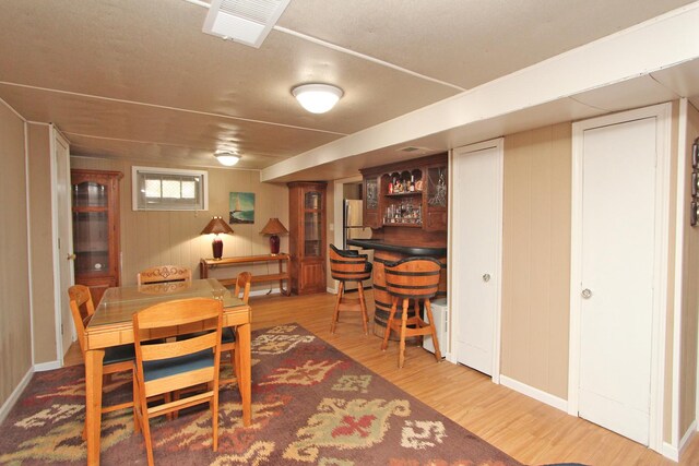 dining area featuring bar and light hardwood / wood-style flooring