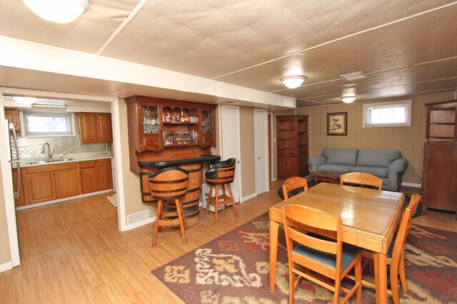 dining space featuring sink, plenty of natural light, and light hardwood / wood-style flooring