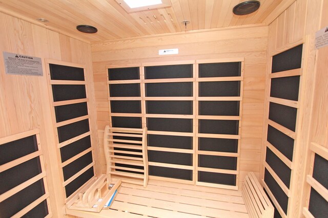 view of sauna with wooden ceiling and wooden walls