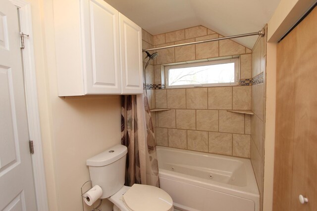 bathroom featuring shower / tub combo with curtain, lofted ceiling, and toilet