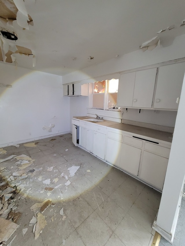 kitchen featuring white cabinets, sink, and light tile flooring