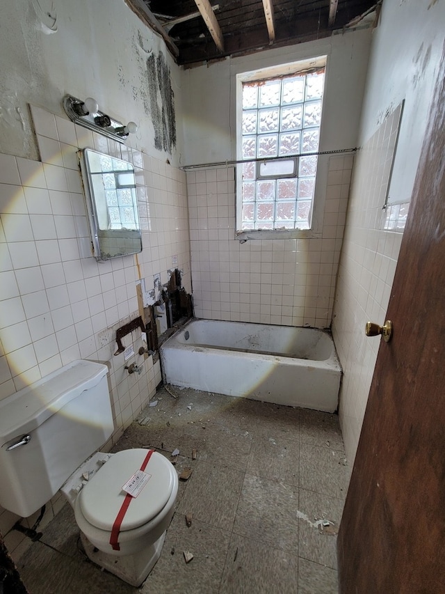 bathroom with tile flooring, toilet, and tile walls