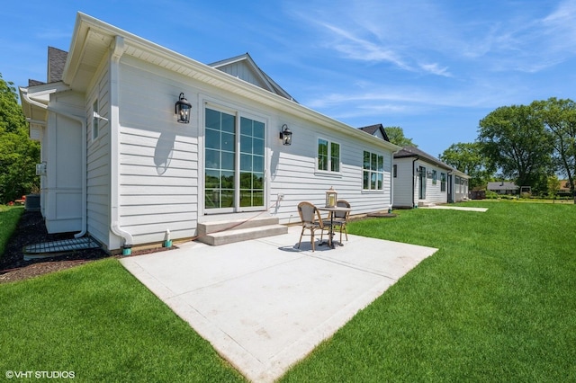 rear view of house featuring a yard and a patio