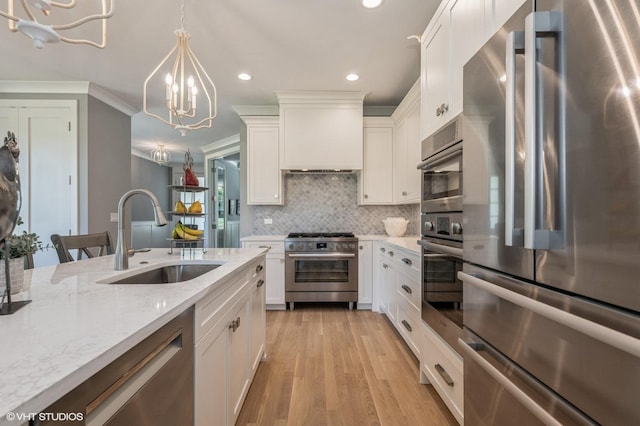 kitchen featuring sink, a notable chandelier, decorative light fixtures, white cabinets, and appliances with stainless steel finishes