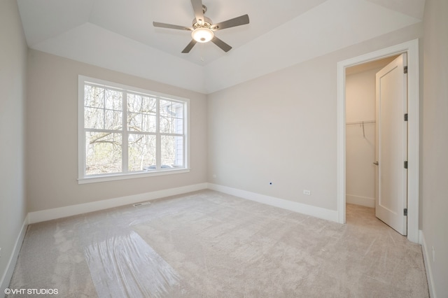 empty room with carpet floors, lofted ceiling, plenty of natural light, and ceiling fan