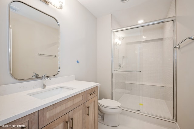 bathroom with a shower with shower door, toilet, and vanity with extensive cabinet space