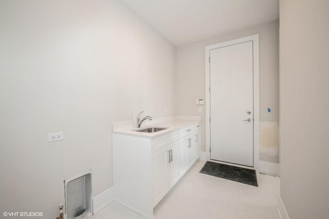 clothes washing area with sink and light tile floors