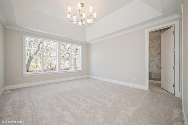 empty room featuring a tray ceiling, crown molding, carpet flooring, and an inviting chandelier