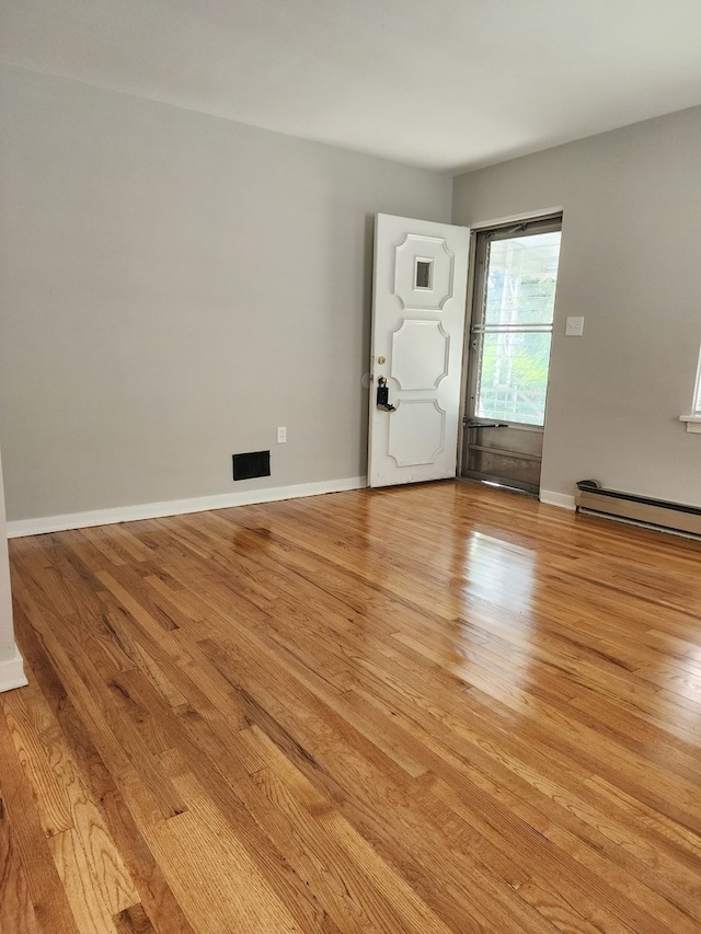 foyer with light wood-type flooring and a baseboard radiator