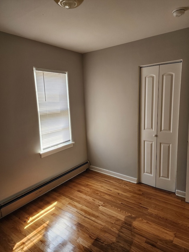 unfurnished room with light hardwood / wood-style flooring and a baseboard radiator