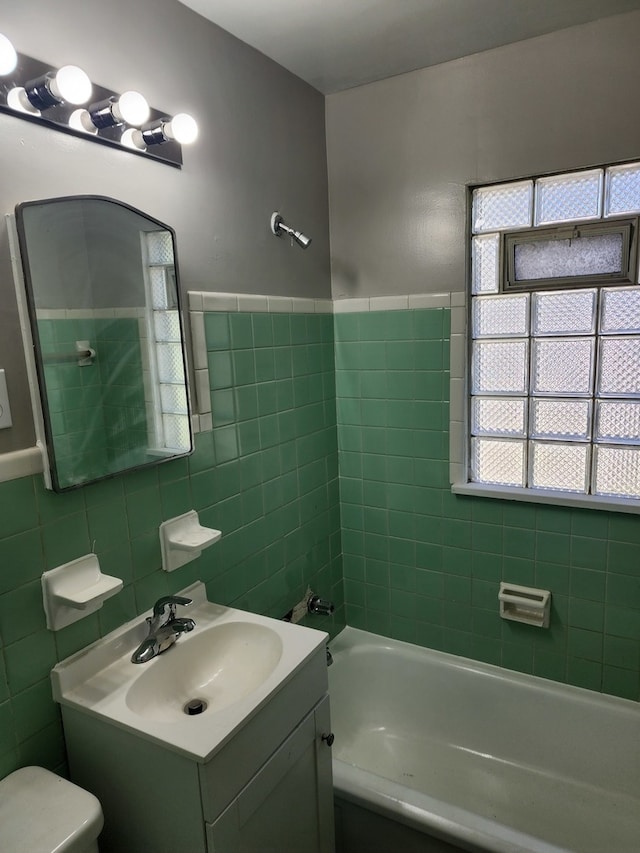 bathroom with vanity, tile walls, and toilet