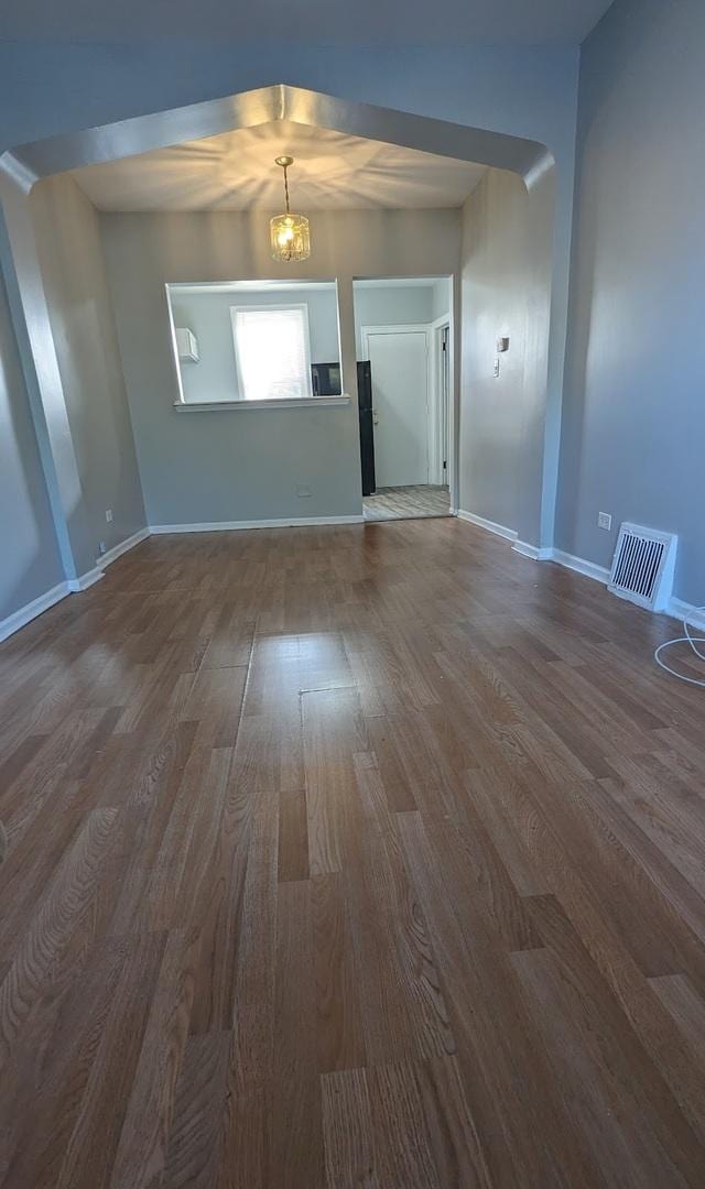 unfurnished room with an inviting chandelier and wood-type flooring