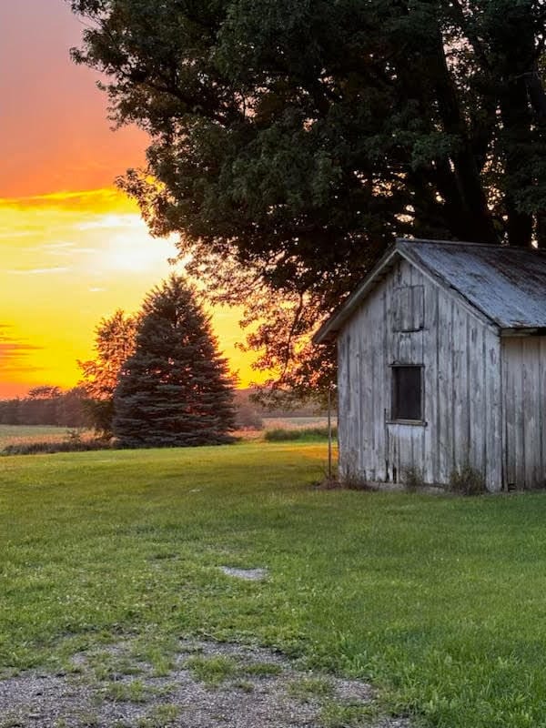 outdoor structure at dusk featuring a lawn