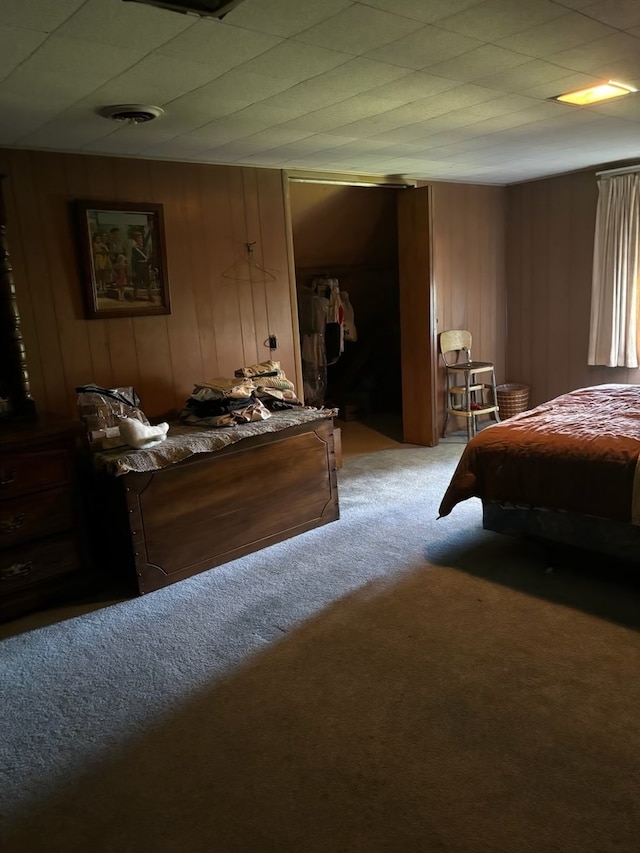 carpeted bedroom featuring wood walls