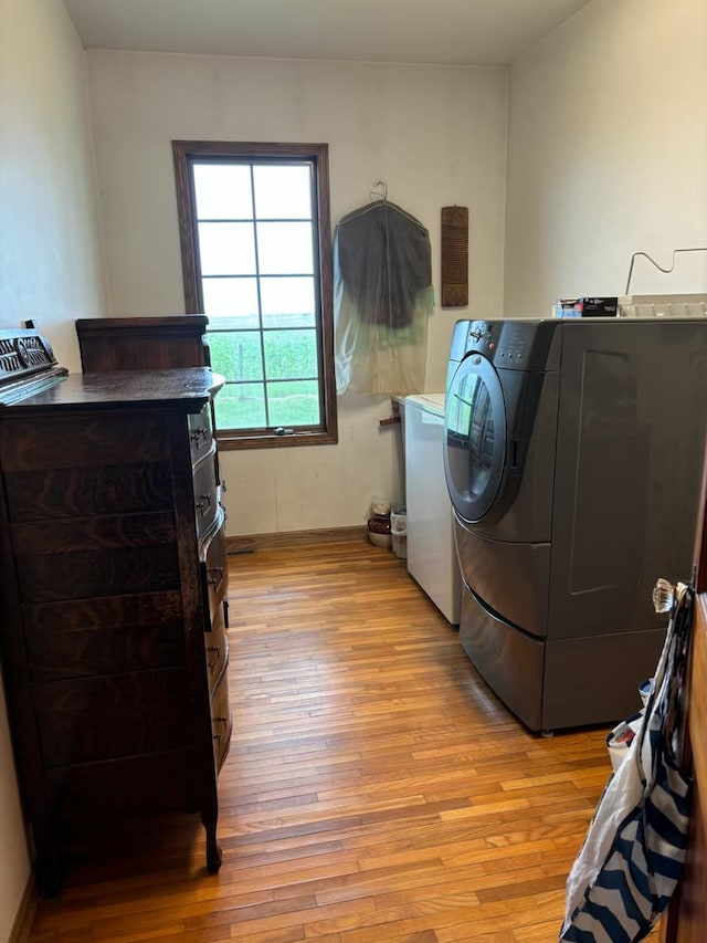 laundry area featuring separate washer and dryer and light wood-type flooring