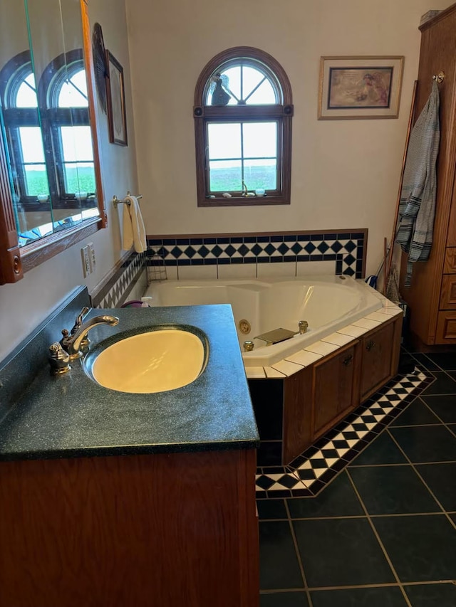 bathroom with tile patterned flooring, vanity, and a tub to relax in