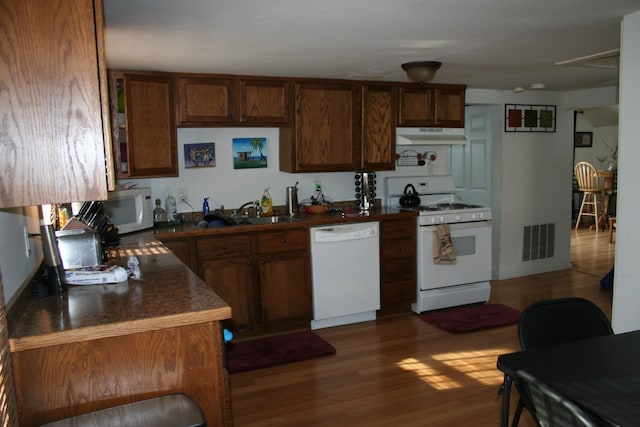 kitchen featuring sink, dark hardwood / wood-style floors, and white appliances