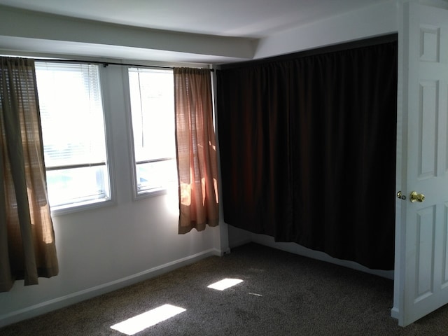 carpeted spare room featuring plenty of natural light