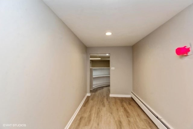 hallway featuring light wood-type flooring and a baseboard radiator