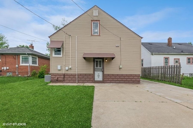 rear view of property with a lawn and cooling unit