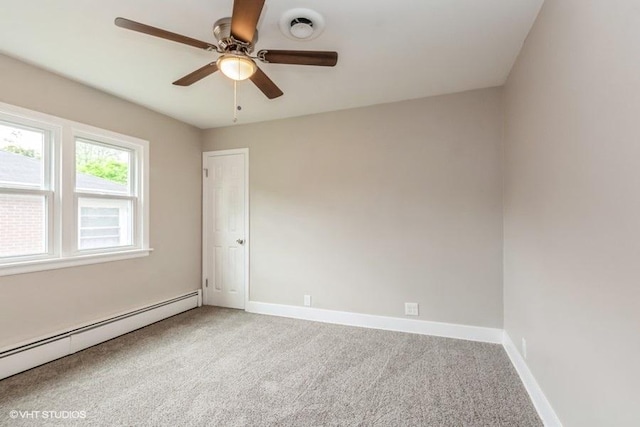 carpeted spare room featuring baseboard heating and ceiling fan