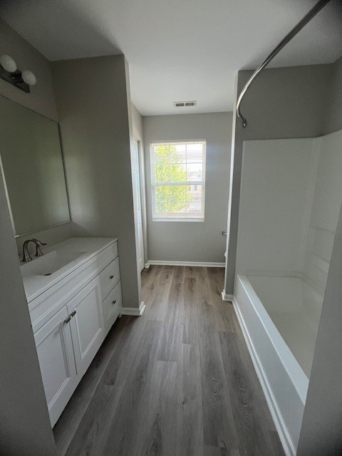 bathroom with vanity, hardwood / wood-style flooring, and tub / shower combination