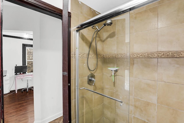 bathroom with hardwood / wood-style flooring and a shower with door