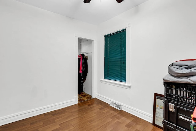 bedroom featuring ceiling fan, a closet, and hardwood / wood-style flooring