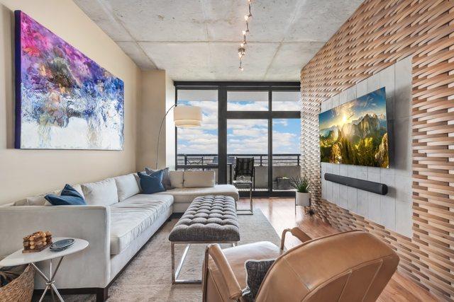 living room with a wall of windows and light hardwood / wood-style flooring