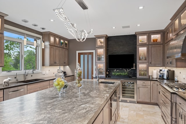 kitchen featuring sink, beverage cooler, a notable chandelier, and decorative light fixtures