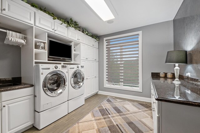 laundry area with sink, cabinets, independent washer and dryer, and light hardwood / wood-style floors