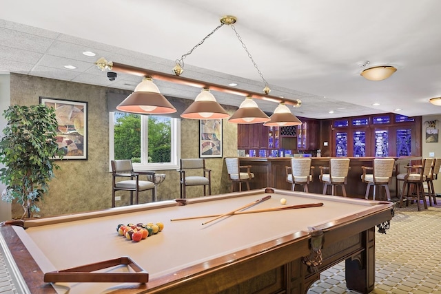 playroom with pool table, a paneled ceiling, and bar area