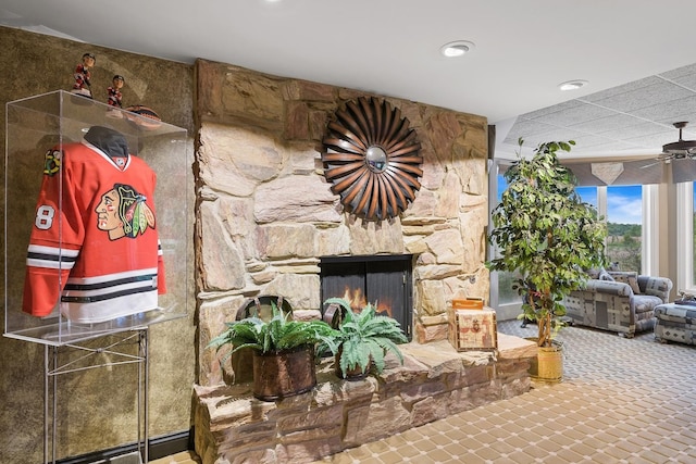 living room with ceiling fan and a fireplace