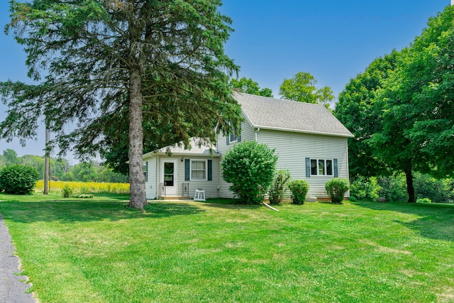 view of front facade with a front lawn and roof with shingles