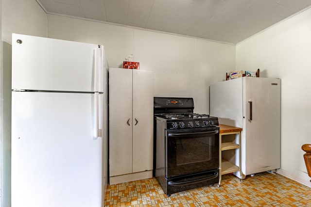 kitchen with freestanding refrigerator and black gas stove