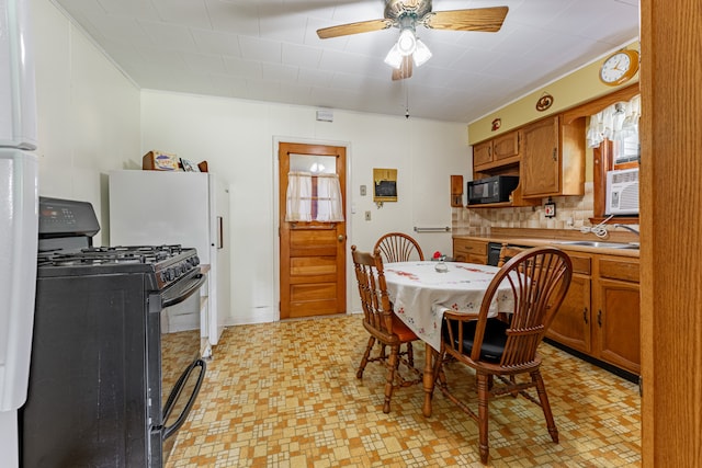 kitchen with ceiling fan, brown cabinets, light countertops, black appliances, and a sink